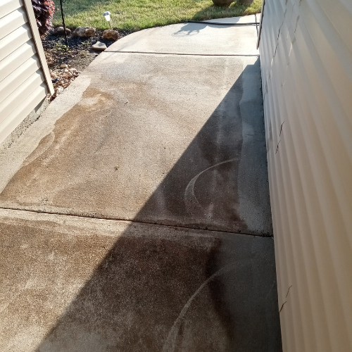 A concrete sidewalk before being pressure washed.
