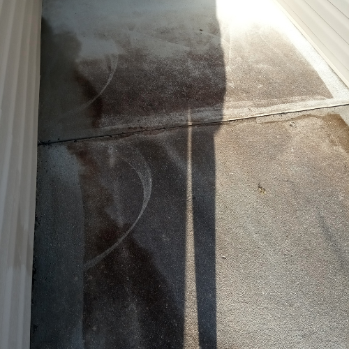 A concrete sidewalk before being cleaned.