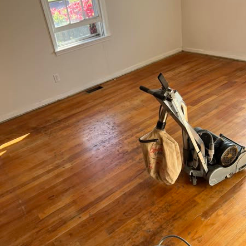 Pre sanded wood floors with the floor sander in frame.