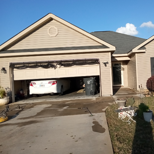 A curbside view of a home with a pressure washed driveway.