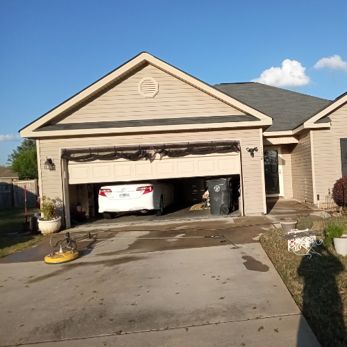 A curbside view of a home with a pressure washed driveway.