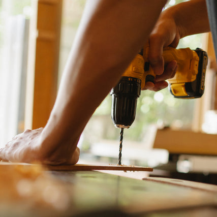 Home Repair RentalsA yellow power drill being used to drill a hole into a piece of wood